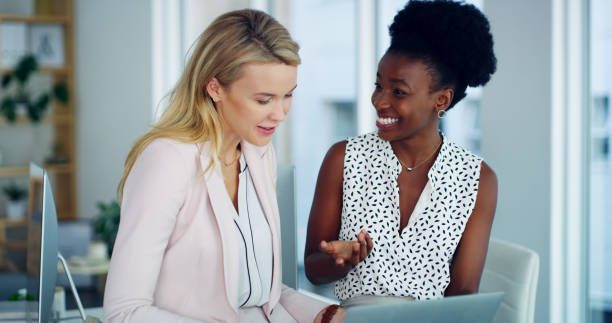 Shot of two businesswomen working together on a laptop in an office